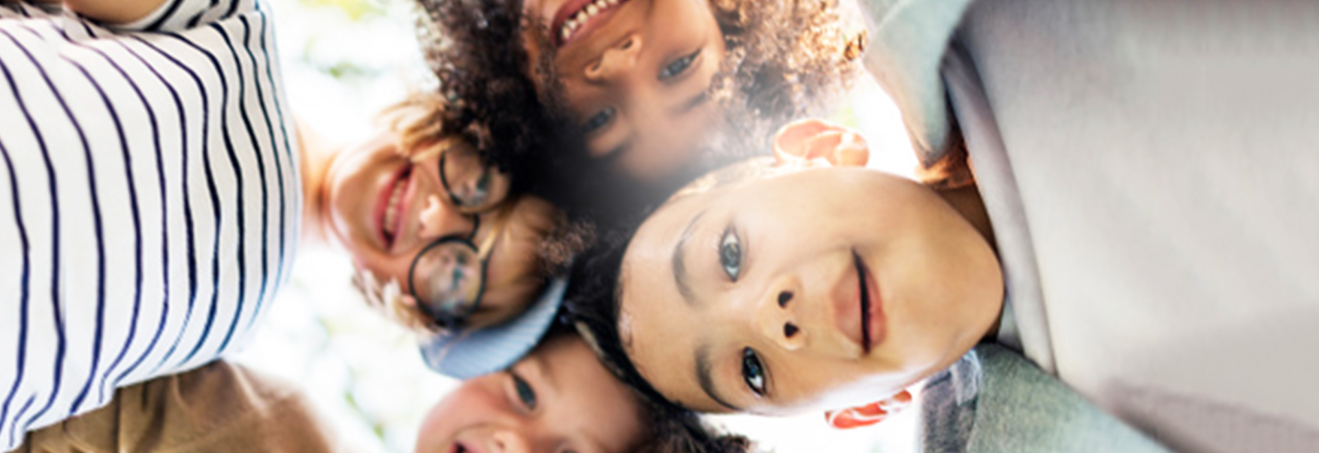 Image of children looking down into camera