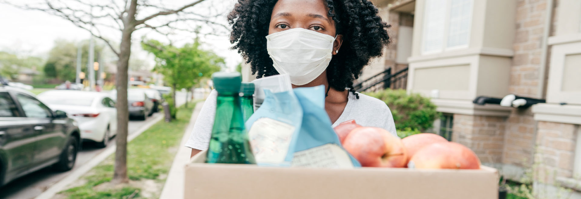 Woman wearing mask with food and drink supplies.